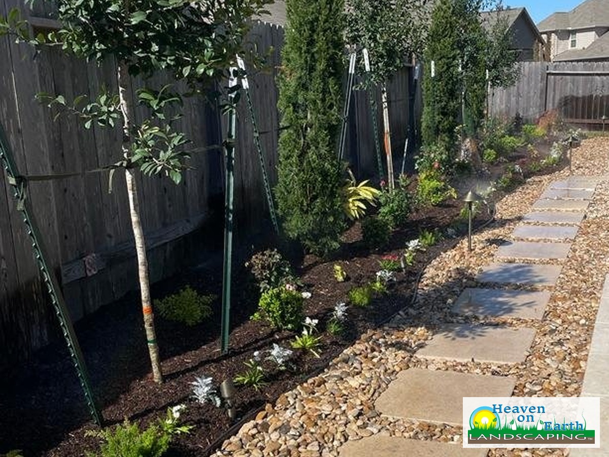 Heaven on Earth Landscaping stone path and planted garden, with company logo in the bottom-right corner